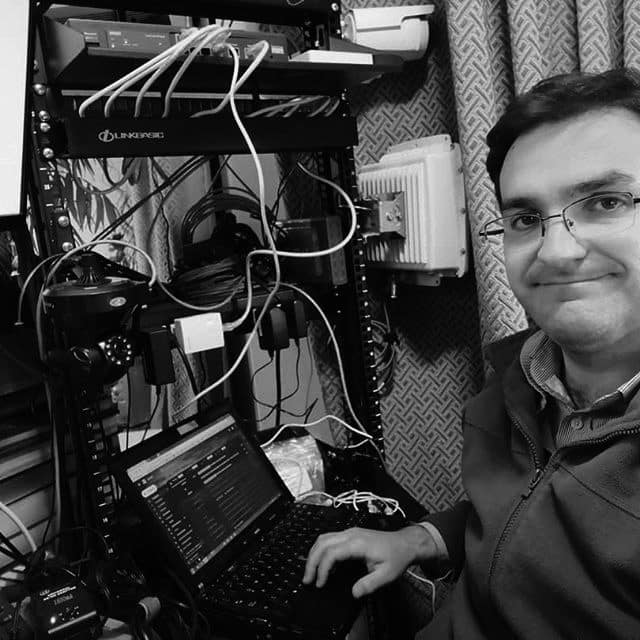 Jerson Fuentes trabajando en su estación de pruebas de redes computacionales para hacer pruebas de configuraciones para clientes